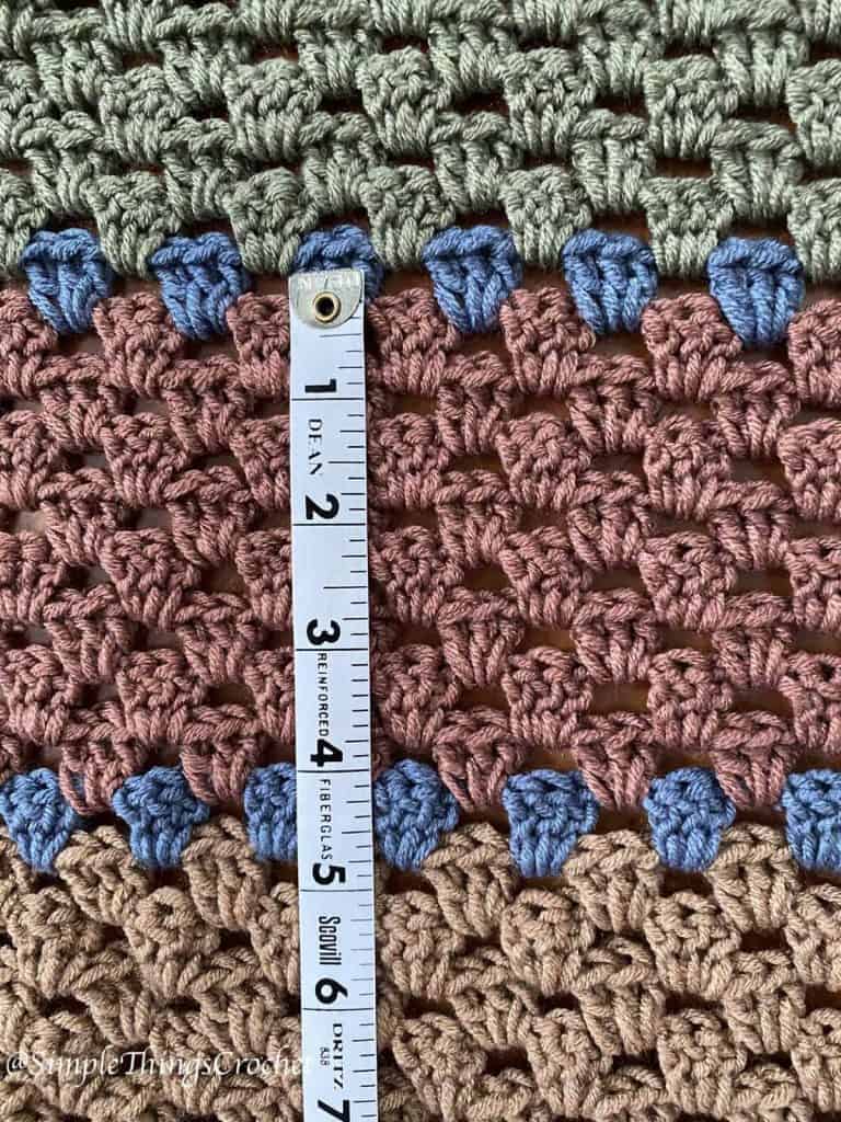 Close-up of Autumn Woods Wrap crochet granny stitch texture showing shells for gauge