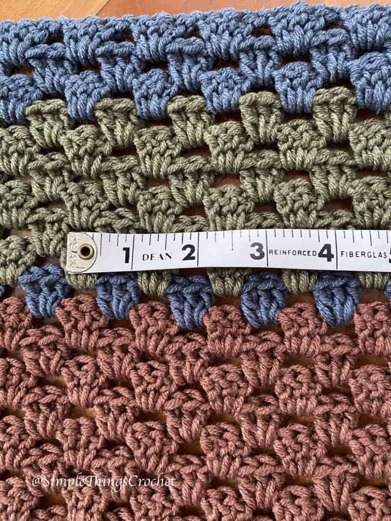 Close-up of Autumn Woods Wrap crochet granny stitch gauge in Stone Wash, Caper, Raisin and Nutmeg yarn